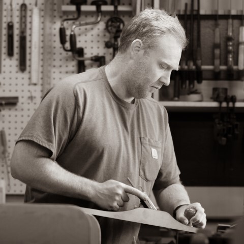 Nickolas using a hand plane, to plane a piece of wood